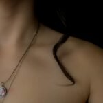 Close-up of a woman's collarbone wearing a delicate necklace, highlighting elegant jewelry.