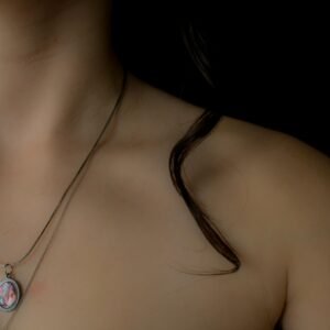 Close-up of a woman's collarbone wearing a delicate necklace, highlighting elegant jewelry.