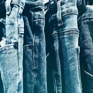 A collection of blue denim jeans hanging closely on a rack in a retail store.